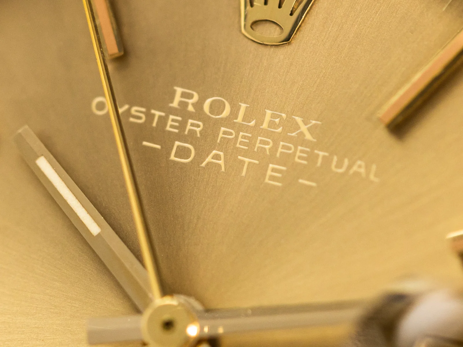 Close view of the champagne dial, baton markers, date window, and Cyclops on ref. 1511