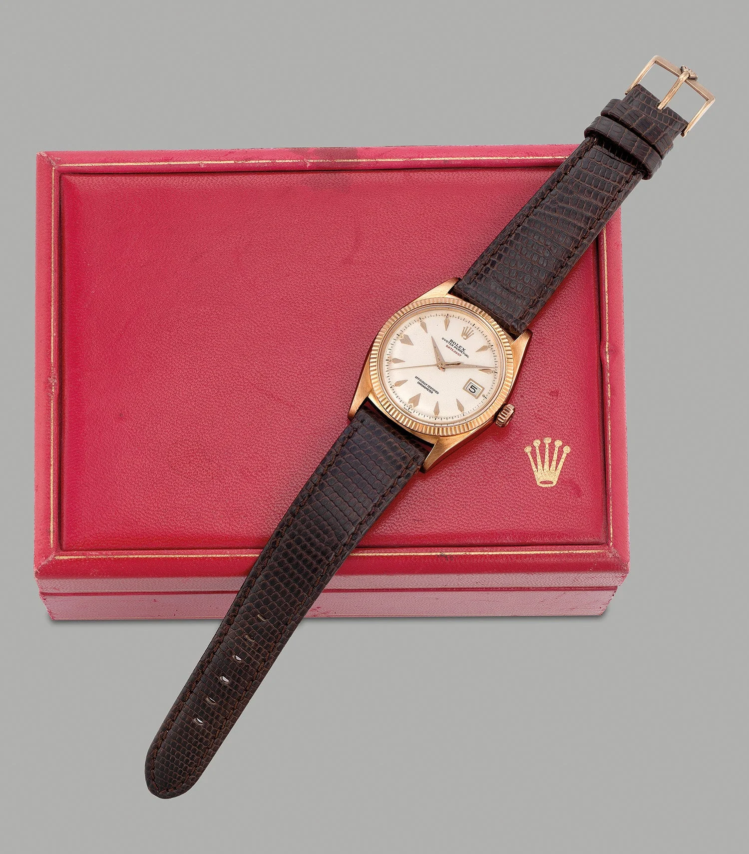 Pink-gold Rolex Datejust 6305 with light dial and red DATEJUST text, photographed beside a presentation box