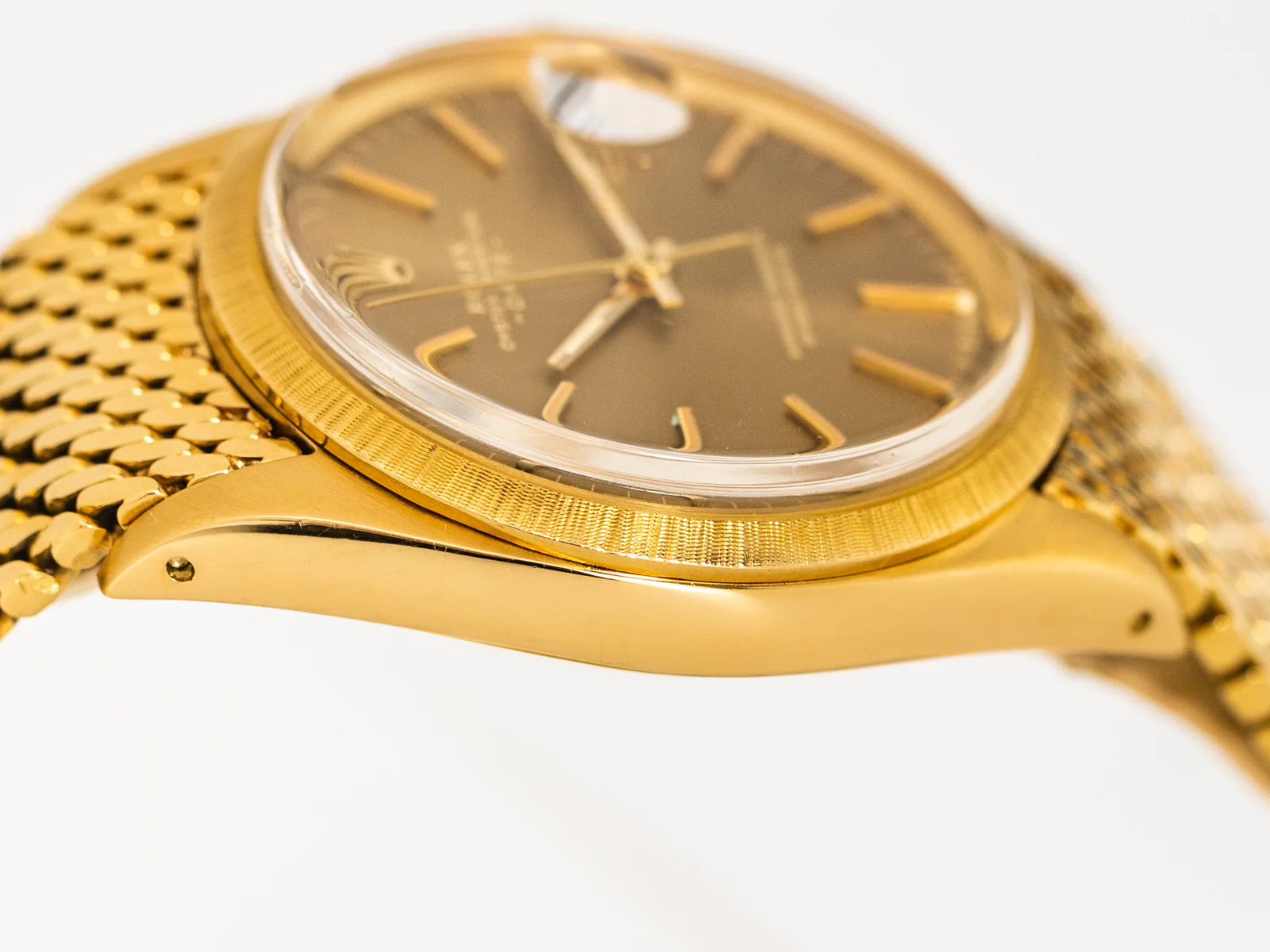 Side profile of the yellow-gold Rolex 1511 showing its textured bezel, crystal, lugs, and crown
