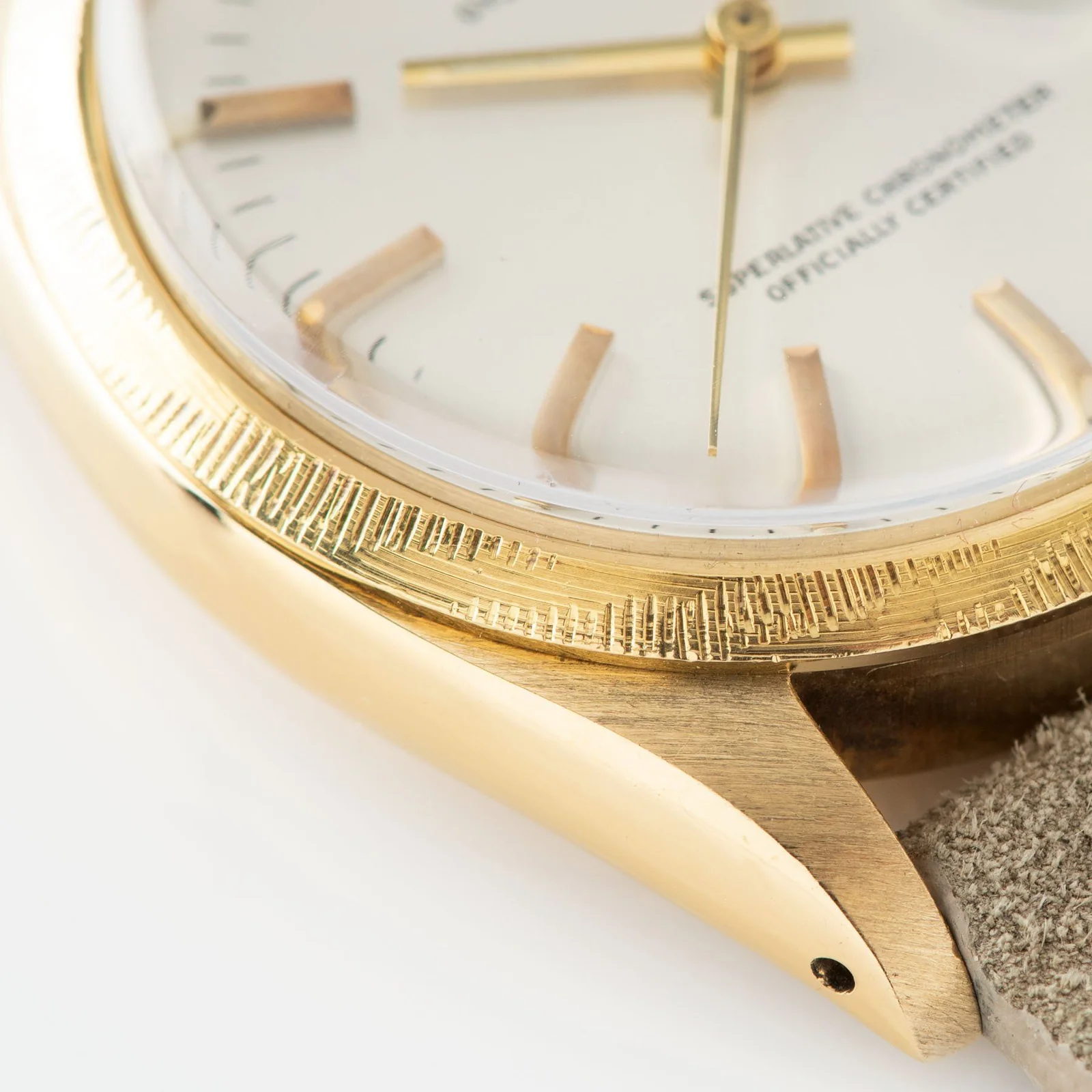 Close view of the patterned yellow-gold bezel and case on a Rolex ref. 1513